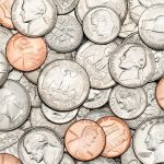 Montón de monedas de oro, monedas de plata, monedas de cobre, cuartos, cinco centavos, diez centavos, centavos, cincuenta céntimos y monedas de un dólar.